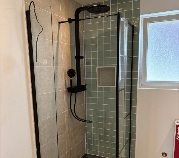 Douche équipée d’une colonne noire et d’une paroi vitrée