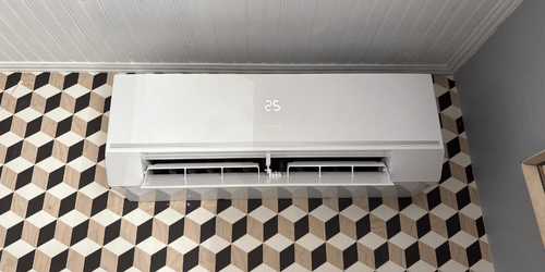 Climatiseur blanc installé sur un mur à motifs géométriques