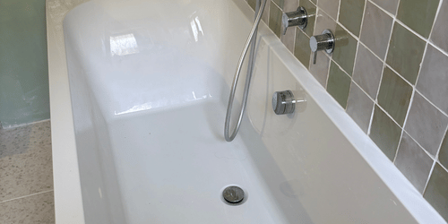 Receveur de douche blanc avec douchette et robinetterie murale
